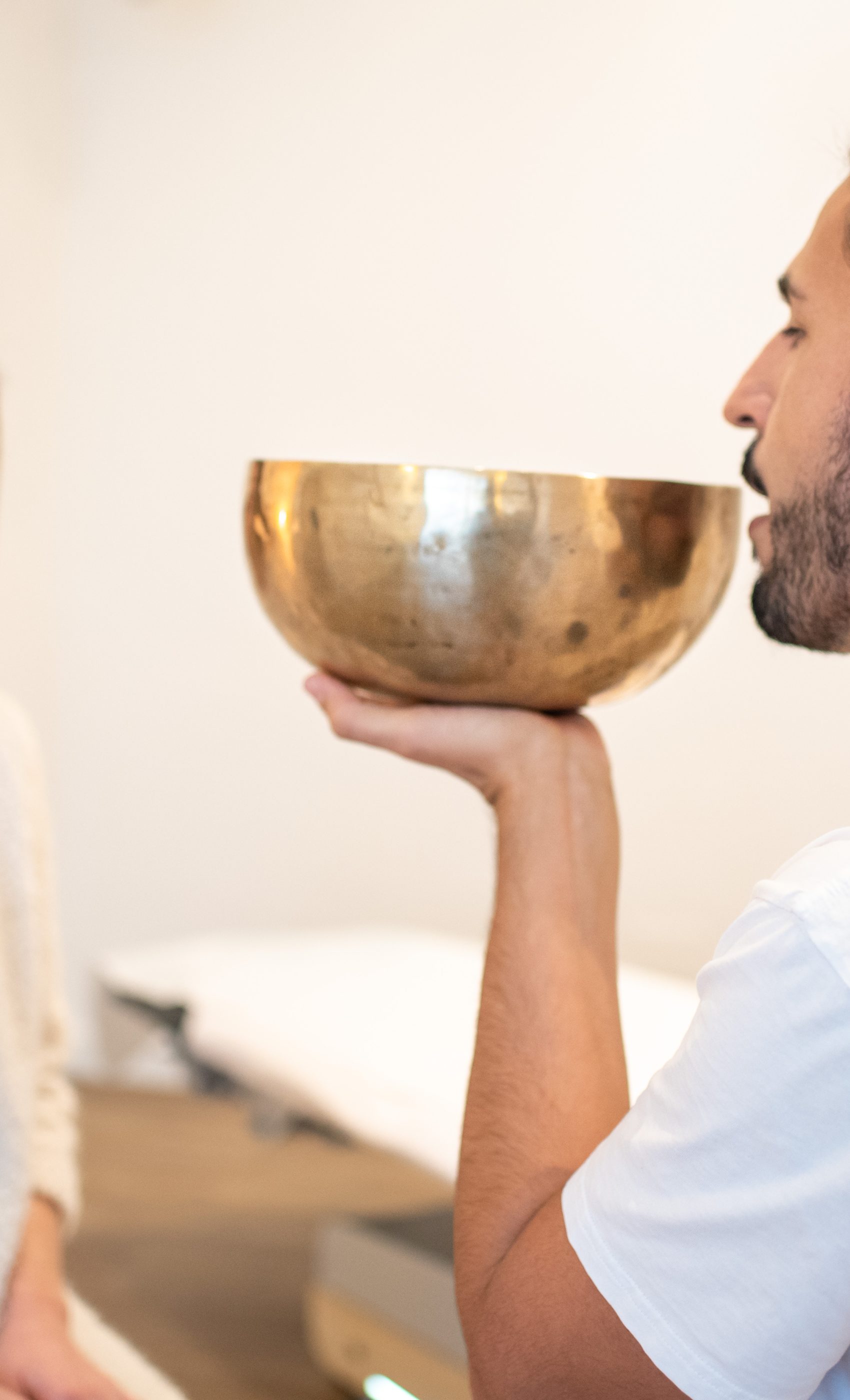 Terapia del suono, campane tibetane e mindfulness Terapia del suono: Donna che riceve una terapia del suono con campane tibetane appoggiate sulla schiena per un rilassamento profondo, Terapia del Suono e Meditazione